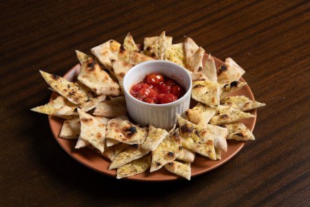 Massa artesanal fina, azeite extravirgem, alecrim e flor de sal, servidos com molho da casa.